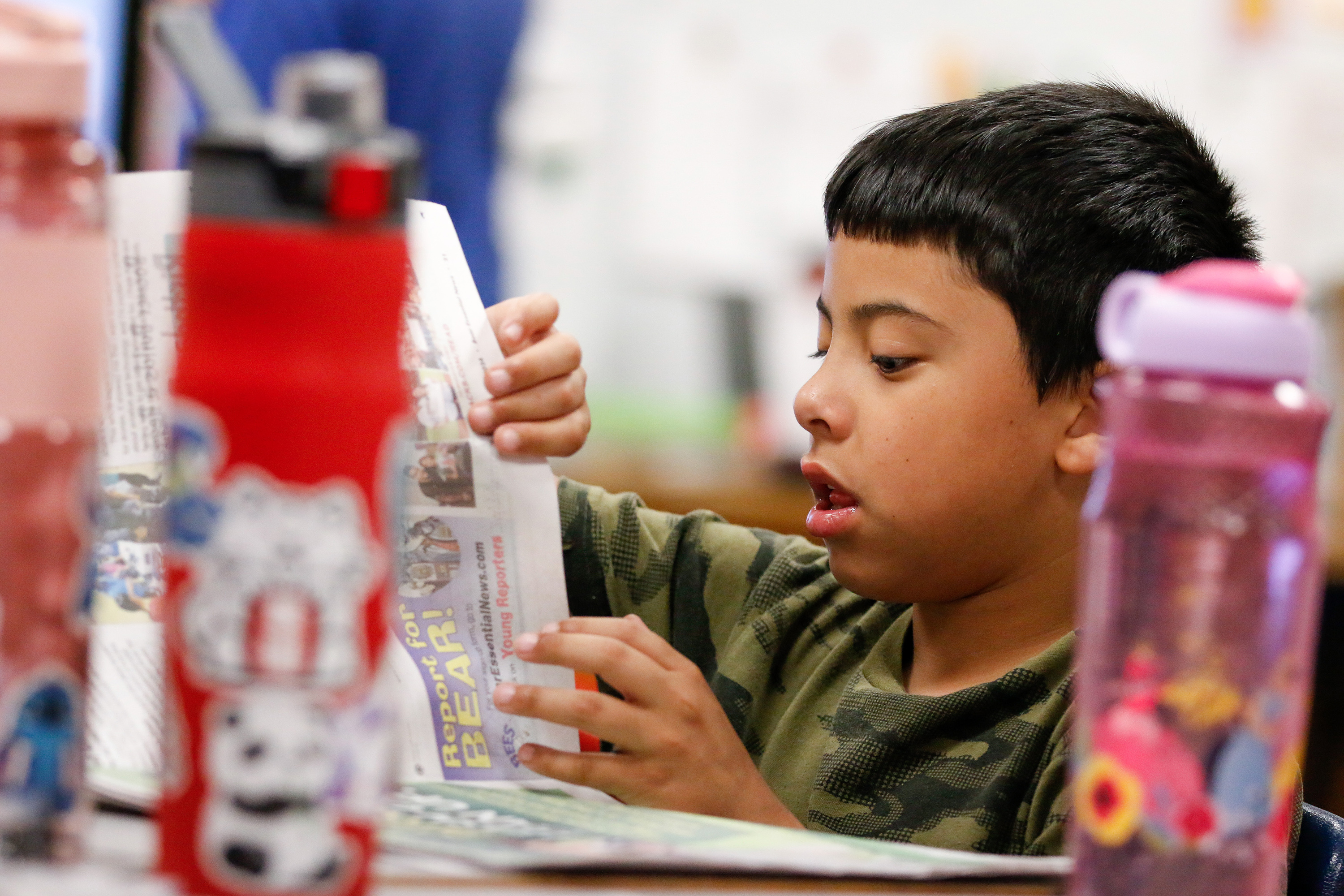 A boy looks at a copy of Bear Essential News