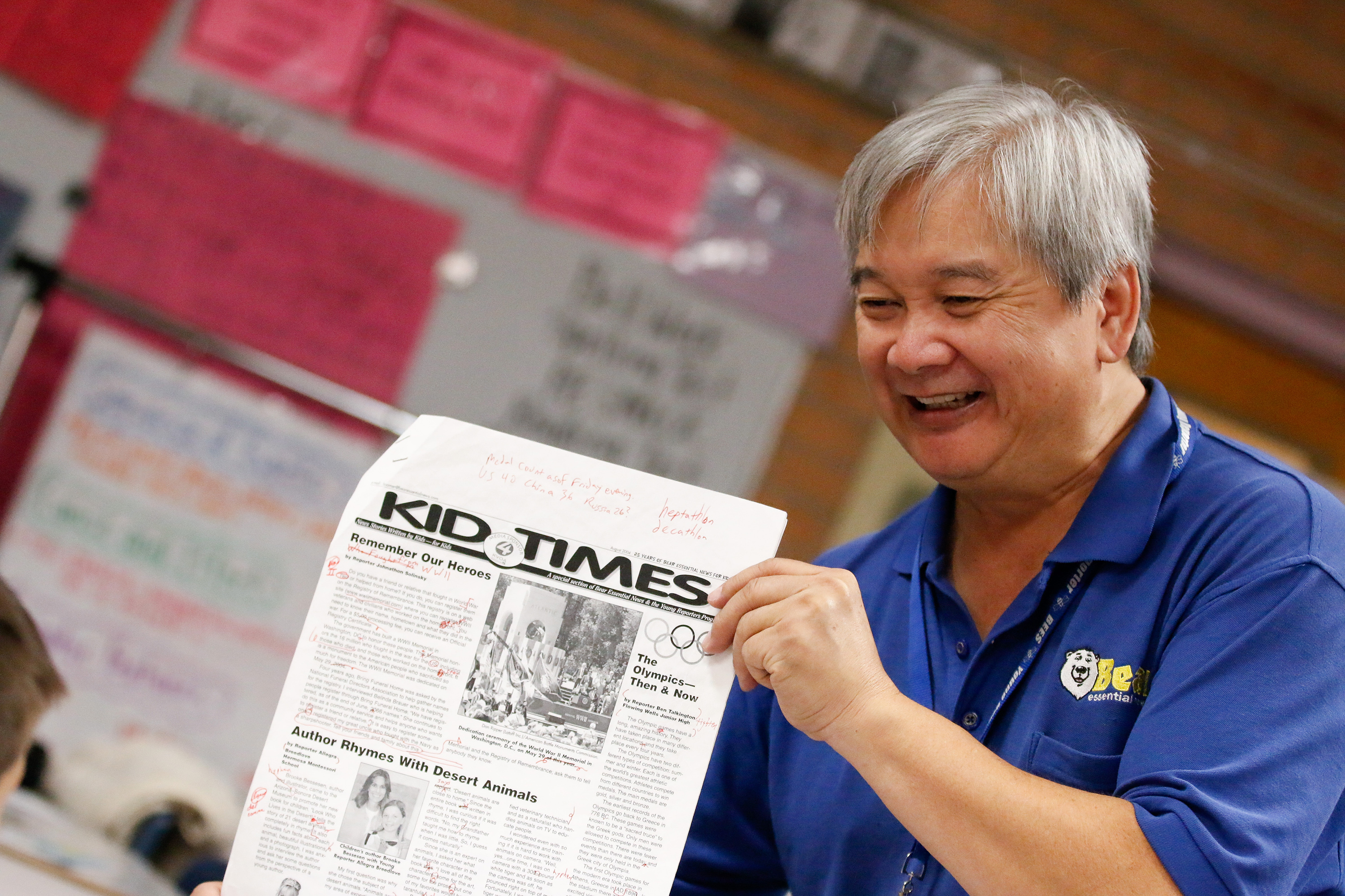 Bear Essential News' Stephen Gin holds up a copy of the newspaper to show students