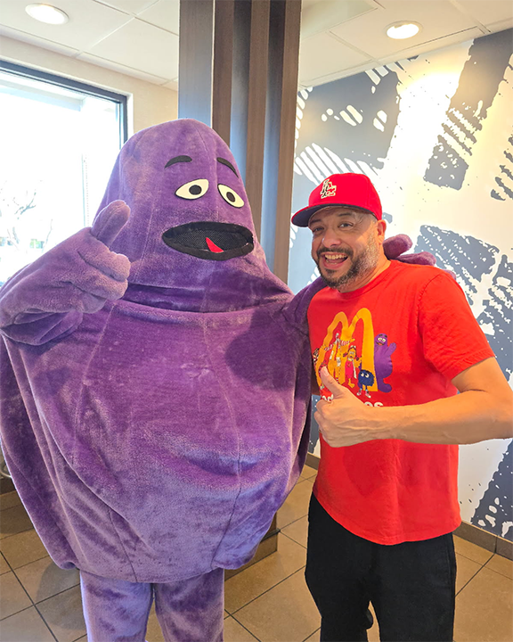 Ford's principal poses for a photo with Grimace, the purple McDonald's character