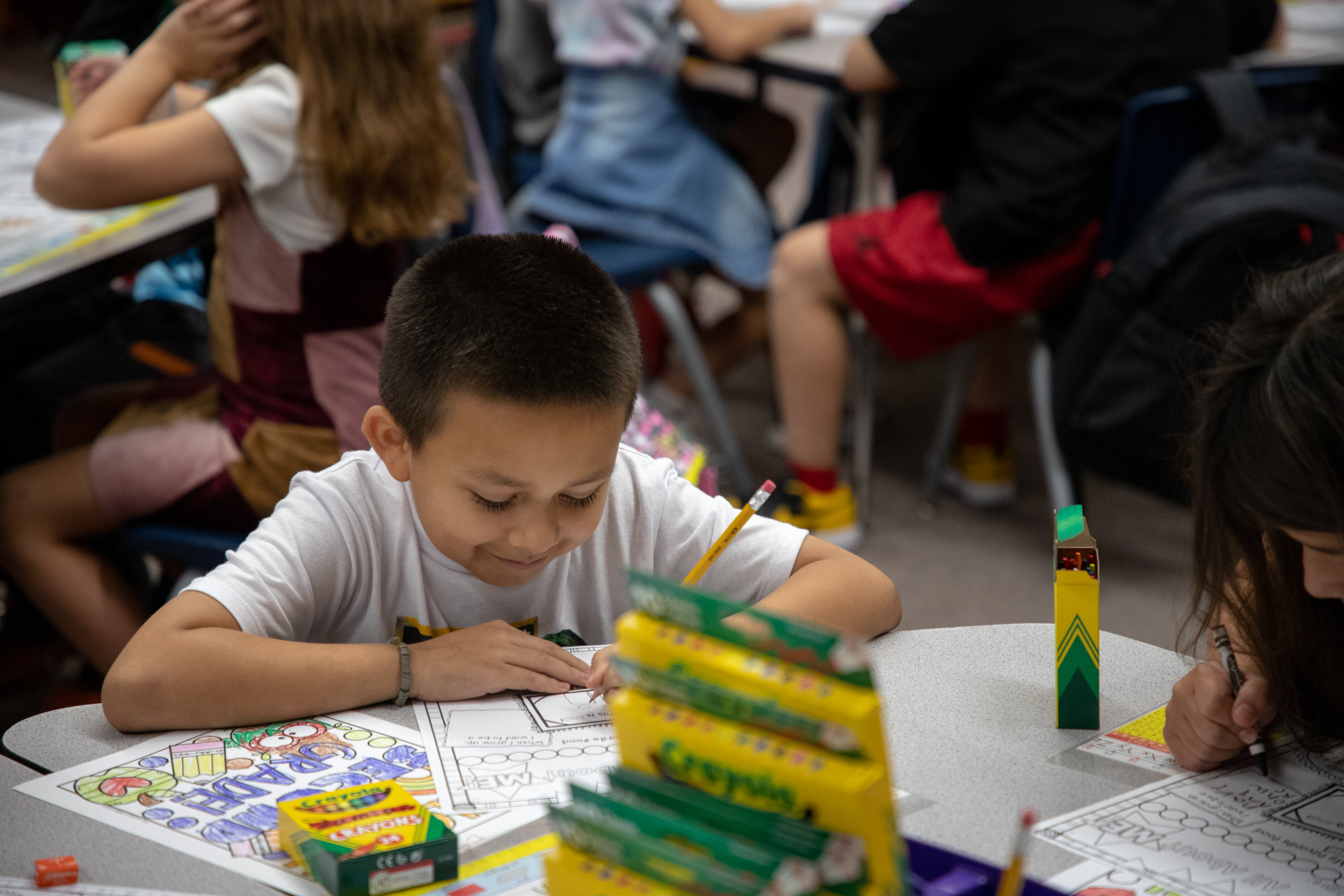 A little boy works on an assignment on the first day of school