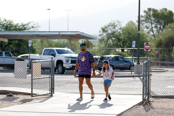 A dad and his daughter walk into school